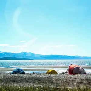 Tents on the shoreline on a blue day