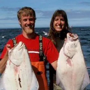 man with two halibut smiling