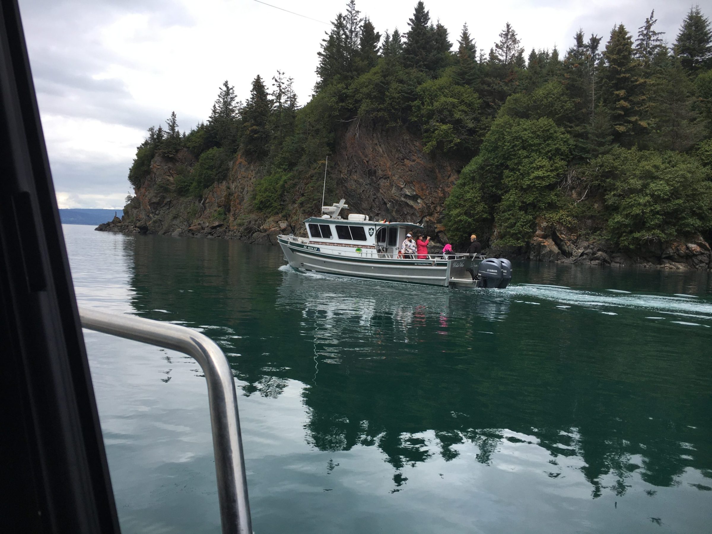 a boat traveling along a river next to a body of water