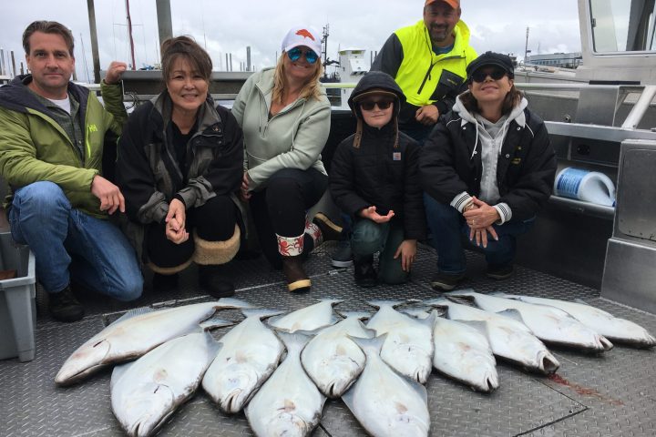a group of people posing for a fish