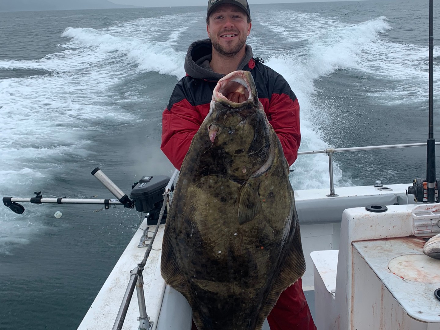 a person holding a fish on a boat in the water