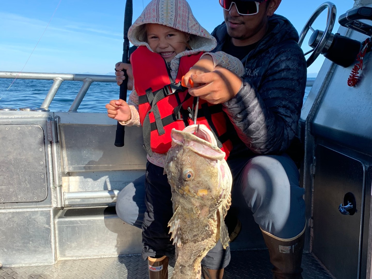 a little boy wearing a hat and sunglasses posing for the camera