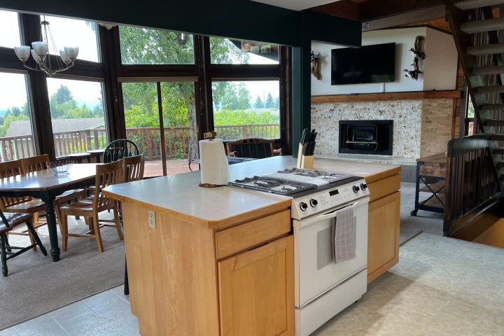 a kitchen with a stove and a large window