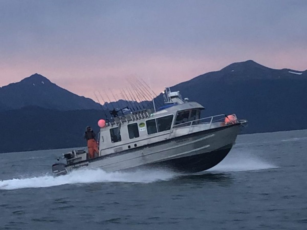 a small boat in a body of water with a mountain in the background