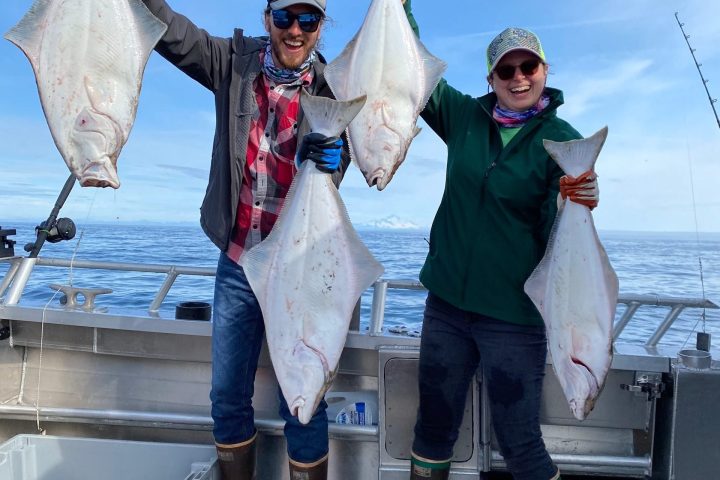 a group of people standing next to a person holding a fish